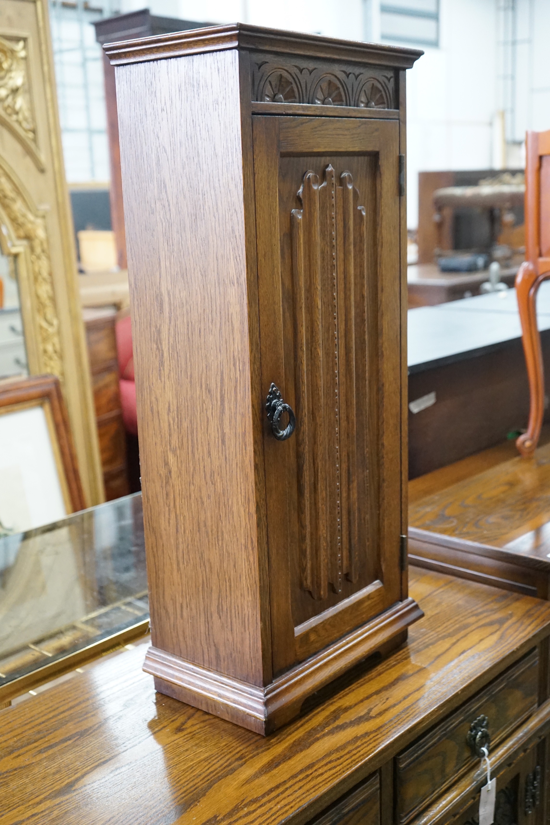 A reproduction 18th century style carved and linen fold moulded oak side cabinet and matching media cabinet, larger width 93cms, depth 43cms height 81cms.